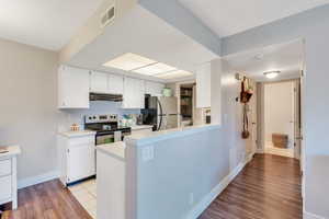 Kitchen with stainless steel appliances, wood finished floors