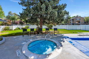 View of swimming pool featuring a lawn, fence, a patio area,  pool and year-round spa