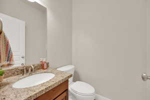 Half bathroom featuring vanity and toilet