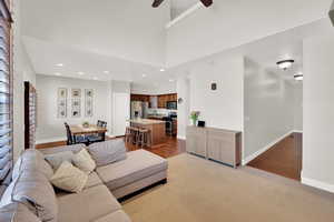 Living room featuring ceiling fan, light colored carpet, light wood-style floors, recessed lighting, and baseboards