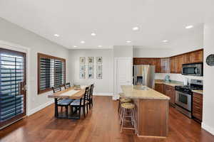 Kitchen with stainless steel appliances, light stone countertops, dark wood finished floors, and a sink