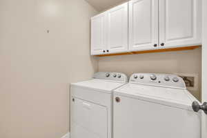 Laundry area featuring cabinet space and washer and clothes dryer
