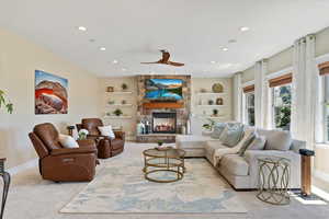 Living area featuring recessed lighting, baseboards, light carpet, and a fireplace
