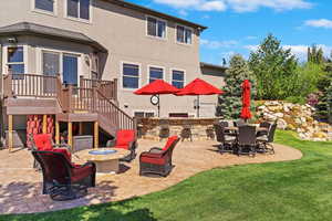 View of patio featuring stairway, a deck, a fire pit, and area for grilling