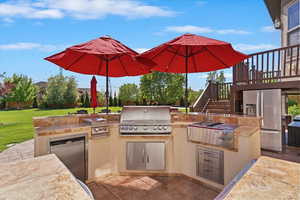 View of patio with a wooden deck, grilling area, stairway, and area for grilling