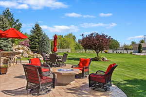 View of patio / terrace with fence, outdoor dining area, and a fire pit