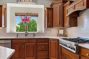 Kitchen with a sink, light countertops, and stainless steel appliances