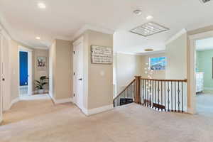 Hallway with carpet floors, baseboards, an upstairs landing, ornamental molding, and recessed lighting