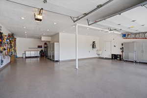 Garage featuring recessed lighting, baseboards, and a garage door opener