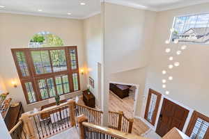 Entrance foyer featuring recessed lighting, crown molding, a towering ceiling, and wood finished floors