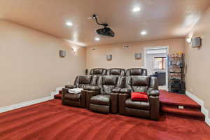 Carpeted cinema room featuring recessed lighting, baseboards, and visible vents