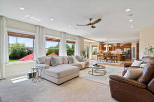 Living area featuring recessed lighting, a ceiling fan, light carpet, and baseboards