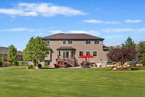 Rear view of property with a patio, stucco siding, and a yard