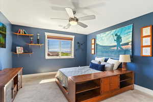 Bedroom featuring baseboards, light colored carpet, and ceiling fan