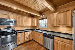 Kitchen with a sink, wooden ceiling, light brown cabinets, and stainless steel appliances