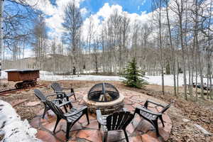 Snow covered patio with a fire pit