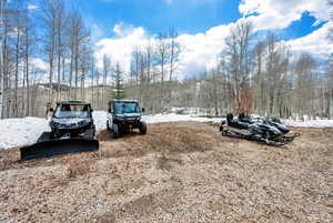 Snow covered parking area with a forest view