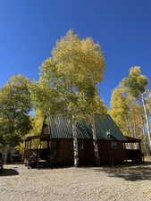 View of side of property featuring metal roof and log veneer siding