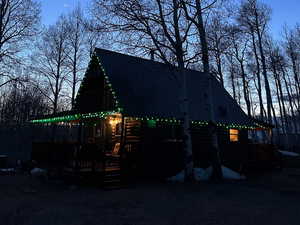 Exterior space with a wooden deck, faux log siding, and metal roof