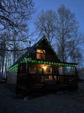 Rear view of house featuring faux log siding and a deck