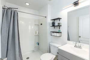 3/4 Ensuite with recessed lighting, a shower with shower curtain, toilet, and vanity