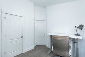 Carpeted home office featuring baseboards