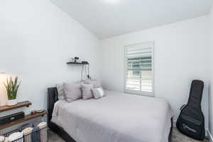 Bedroom with carpet and vaulted ceiling