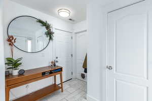 Foyer with visible vents and marble finish floor