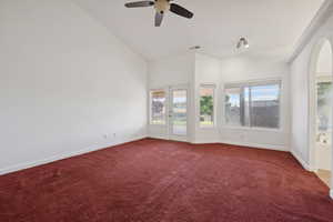 Carpeted spare room with baseboards, plenty of natural light, a ceiling fan, and visible vents