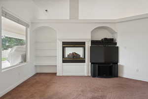 Unfurnished living room with baseboards and carpet