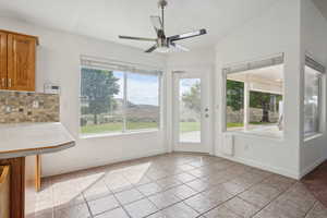 Interior space with baseboards, ceiling fan, and a wealth of natural light