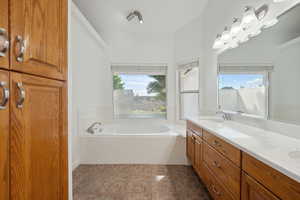 Bathroom featuring a sink, a bath, tile patterned flooring, and double vanity
