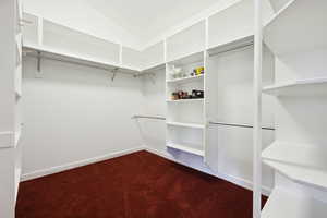 Walk in closet with dark carpet