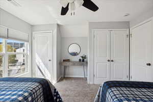 Bedroom with a ceiling fan, a textured ceiling, visible vents, baseboards, and carpet flooring