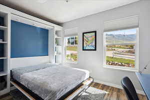Bedroom featuring baseboards, a mountain view, and wood finished floors