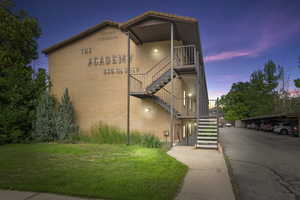 Property at dusk featuring covered parking and stairway
