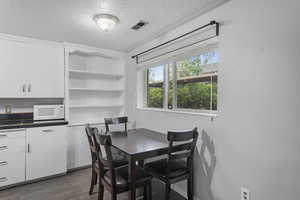 Dining area featuring visible vents, a textured ceiling, and dark tile patterned floors
