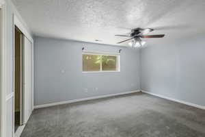 Unfurnished bedroom featuring carpet floors, a textured ceiling, visible vents, and a closet