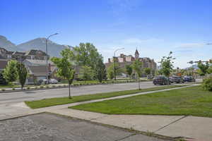View of road featuring a residential view, sidewalks, a mountain view, and street lights