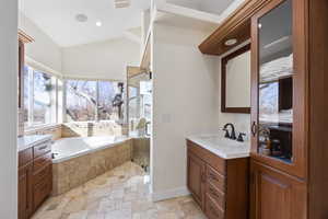 Bathroom with stone tile flooring, a whirlpool tub, vanity, baseboards, and a large digital shower