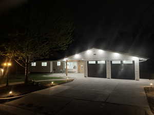 Single story home with a garage, a lawn, and driveway