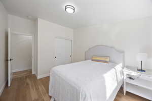 Bedroom featuring a closet, baseboards, and white oak wood flooring
