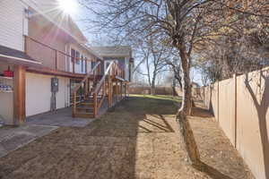 View of yard featuring stairway, a deck, a patio, and a fenced backyard. separate basement entrance.