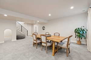 Carpeted open floorplan living space with two-tone paint and recessed lighting