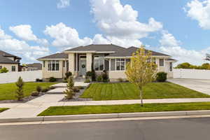 Prairie-style house featuring a front yard, stone siding, and fence
