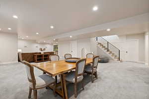 Carpeted open floorplan living space with two-tone paint and recessed lighting