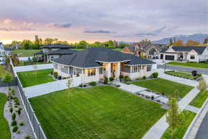 Ranch-style house featuring roof with shingles, a front lawn, a residential view, and a fenced backyard
