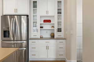 Custom cabinetry feature with glass doors and decorative shelving