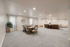 Carpeted open floorplan living space with two-tone paint and recessed lighting