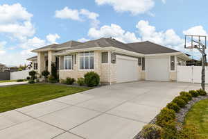 View of front of property with a front lawn, a garage, a gate, stone siding, and fence